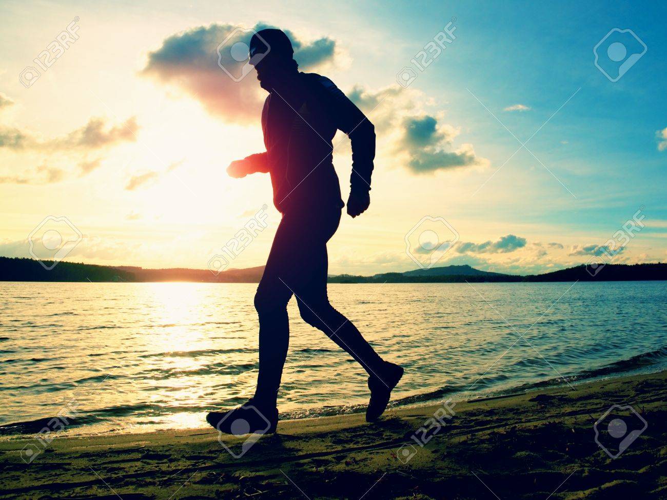 Grosser Mann Mit Sonnenbrille Und Dunkle Kappe Lauft Am Strand Bei Sonnenuntergang Lizenzfreie Fotos Bilder Und Stock Fotografie Image 50042226