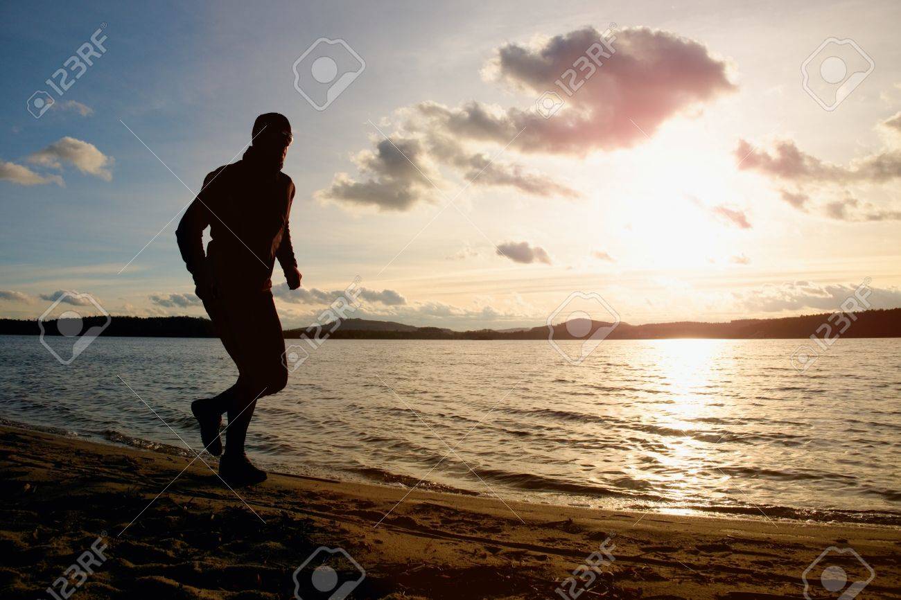 Grosser Mann Mit Sonnenbrille Und Dunkle Kappe Lauft Am Strand Bei Sonnenuntergang Lizenzfreie Fotos Bilder Und Stock Fotografie Image 50043382