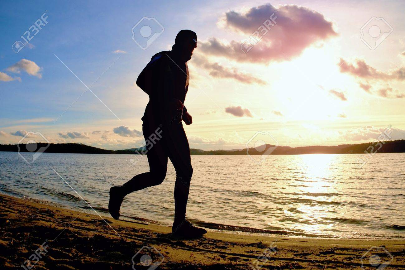 Grosser Mann Mit Sonnenbrille Und Dunkle Kappe Lauft Am Strand Bei Sonnenuntergang Lizenzfreie Fotos Bilder Und Stock Fotografie Image 80735884