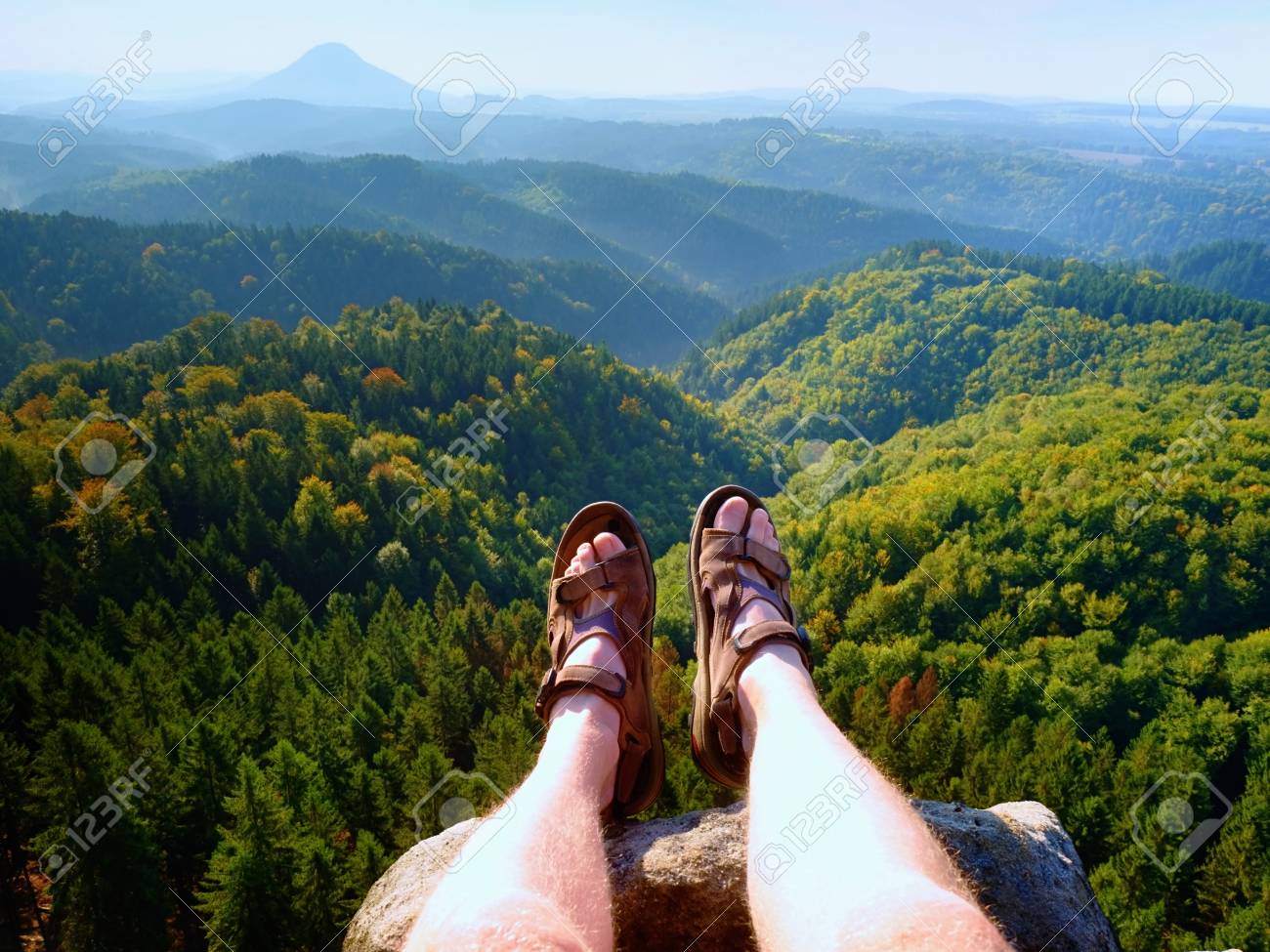 ピーク時のハイキングサンダルで長い疲れた裸の足 砂岩の岩のハイキング 背景に青い曇雲の丘陵風景 の写真素材 画像素材 Image