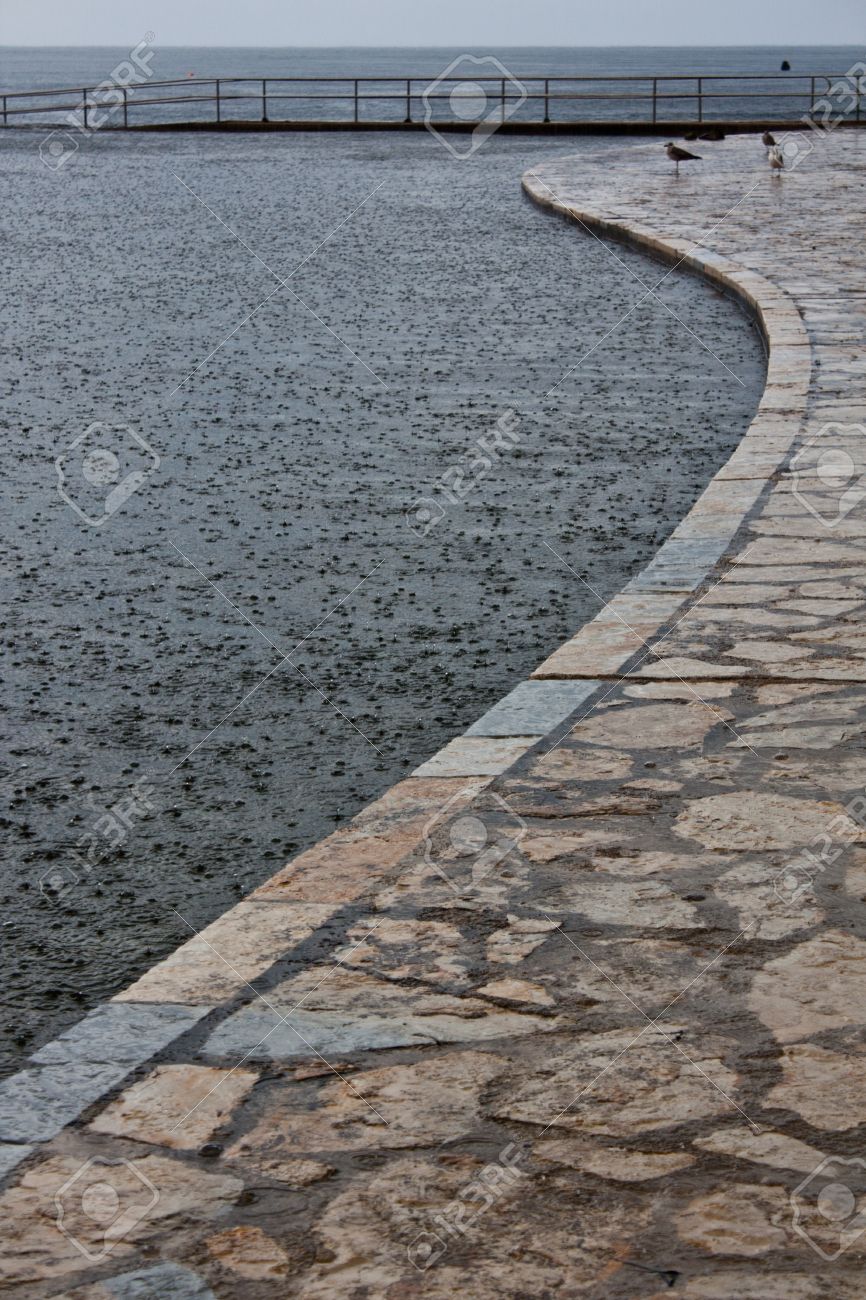 コンクリートと石ラウンド形床海辺の近くに小さなドック 雨の日目に見える雨 の写真素材 画像素材 Image