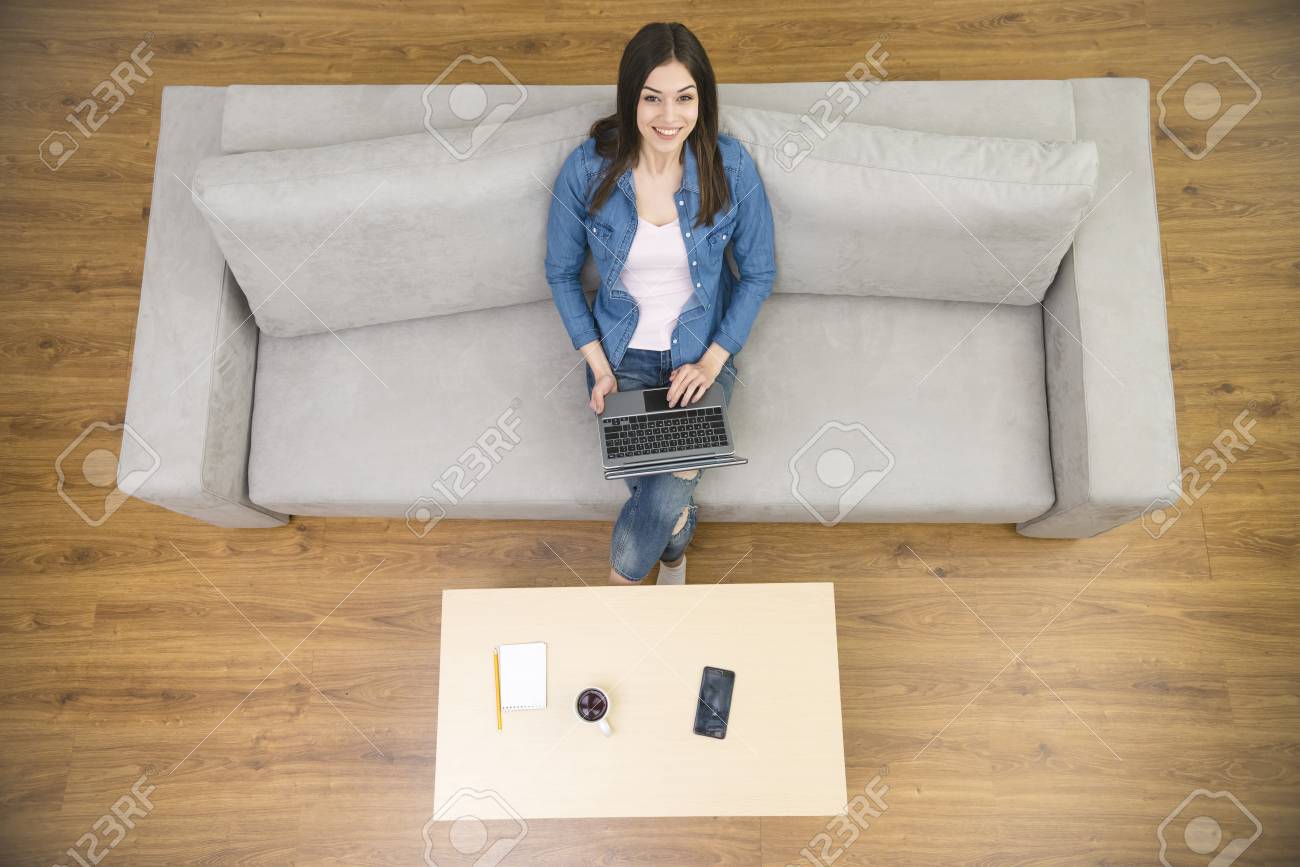 ノート パソコンで幸せな女は ソファに座る 上からの眺め の写真素材 画像素材 Image