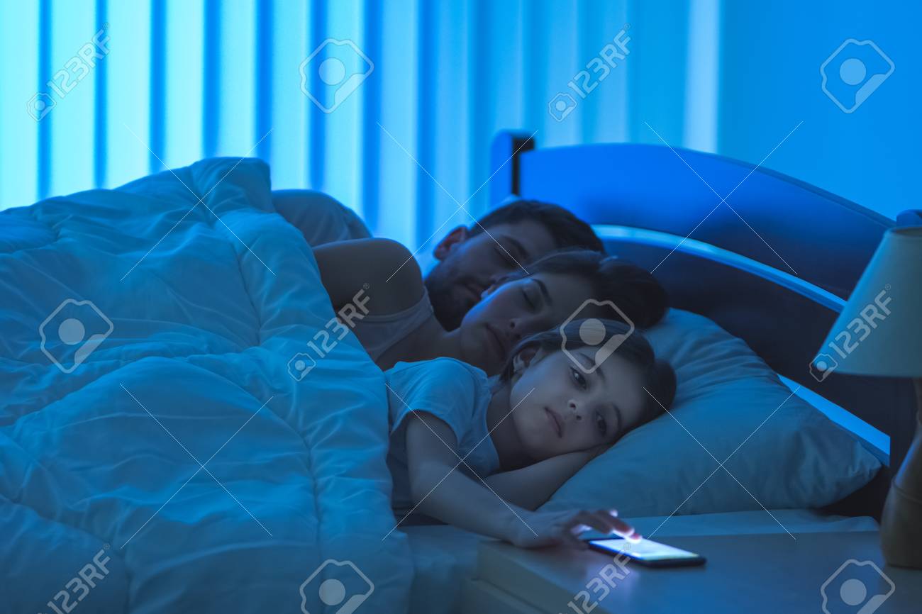 ベッドに寝ている両親に近い女の子の携帯電話 夜の時間 の写真素材 画像素材 Image ベッドに寝ている両親に近い女の子の携帯電話 夜の時間 の写真素材 画像素材 Image