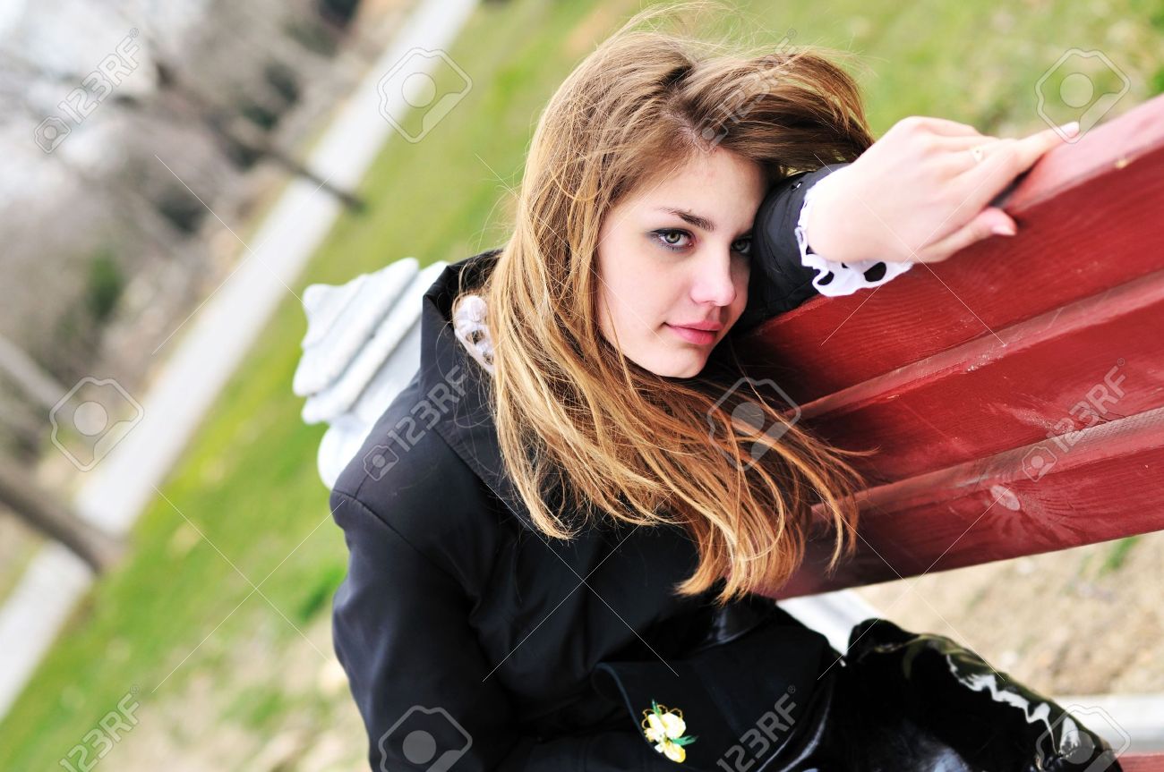 sad girl on the bench in the park stock photo picture and royalty