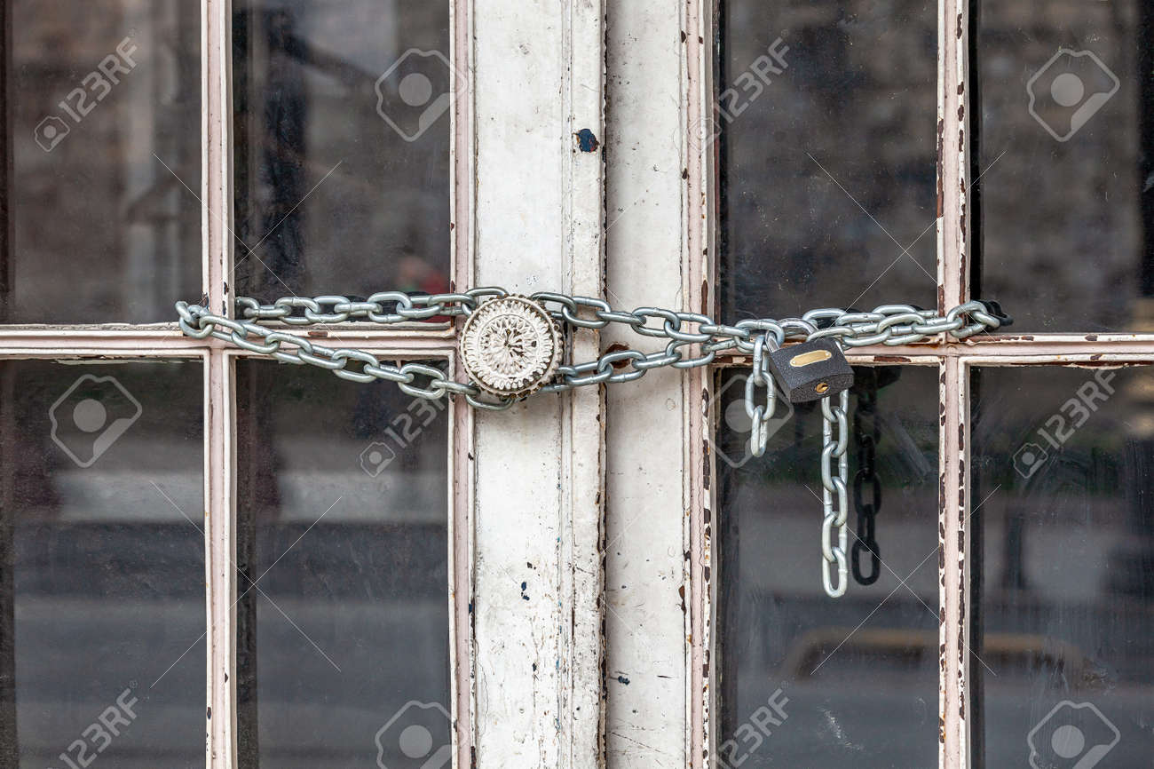 Iron lock and chain on an old rusty door - 163886703 Iron lock and chain on an old rusty door - 163886703