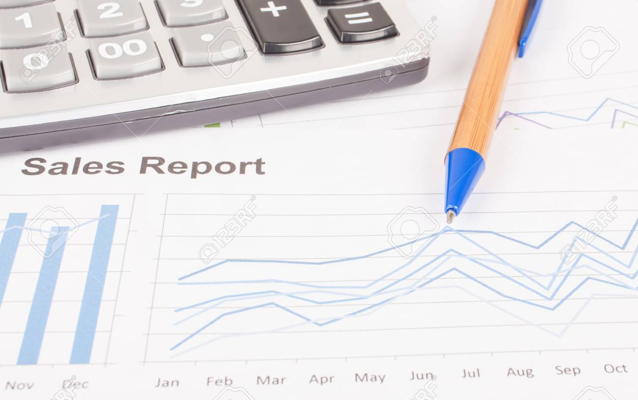 sheet of sales report with pen and calculator stock photo picture
