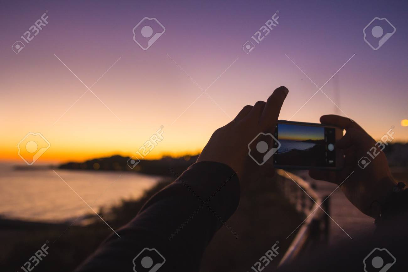 Prendre La Photo Du Coucher De Soleil Violet à Locéan Avec Téléphone Portable