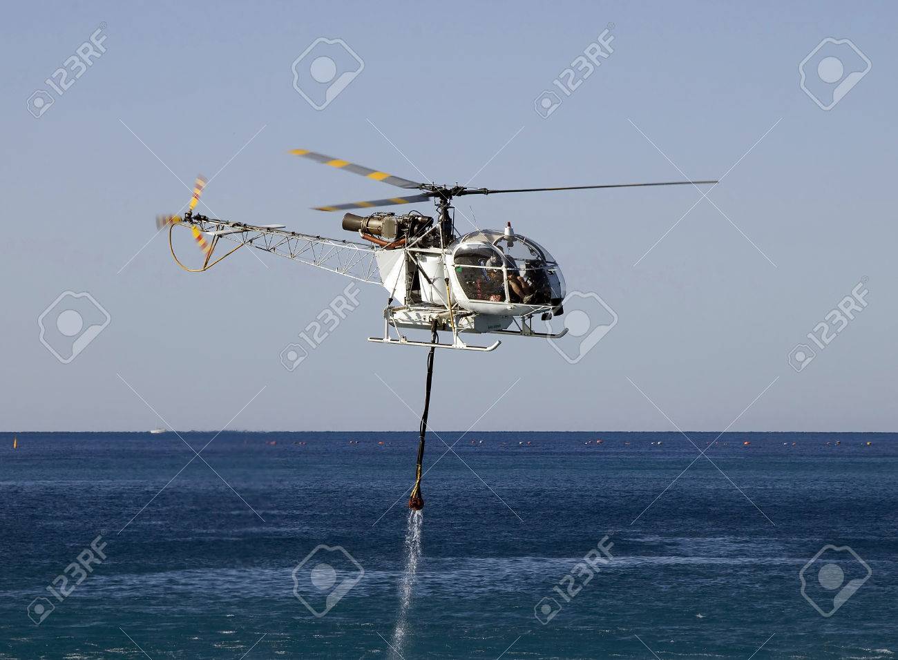 FIRE FIGHT HELICOPTER WITH WATER BUCKET AT SEA - 32203624 FIRE FIGHT HELICOPTER WITH WATER BUCKET AT SEA - 32203624