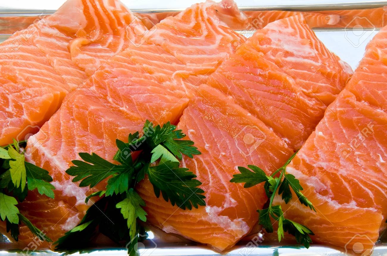 Four chunks of salmon fillet on a silver dish with parsley leaves - 33975699 Four chunks of salmon fillet on a silver dish with parsley leaves - 33975699