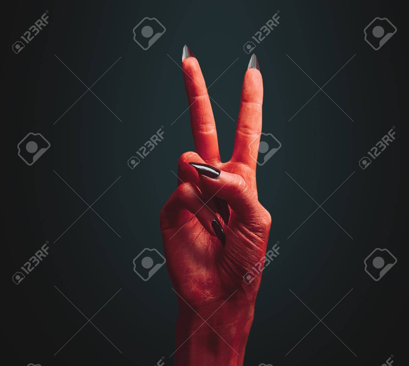 red devil hand on dark peace hand sign halloween or horror