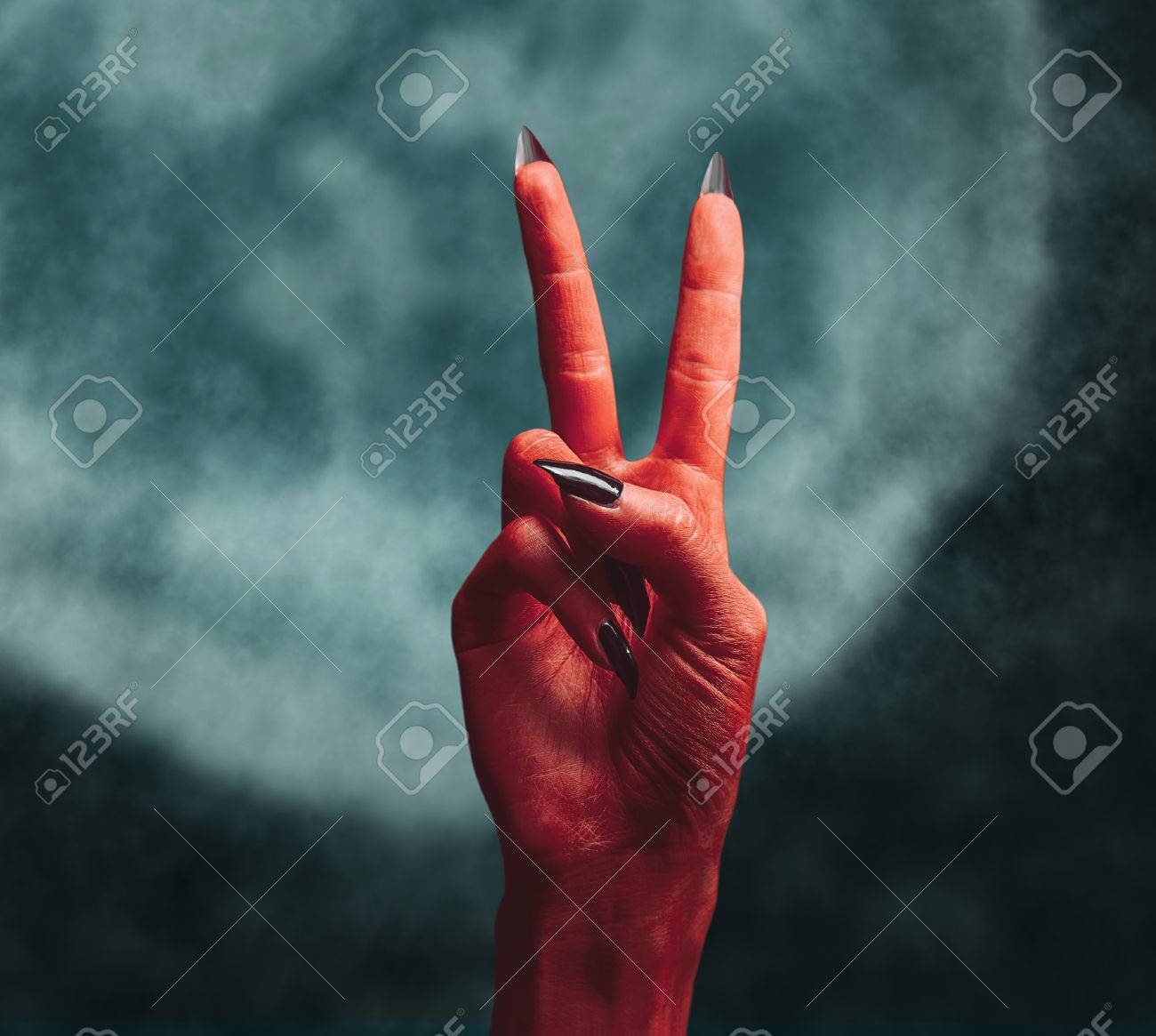 red devil hand on dark peace hand sign halloween or horror