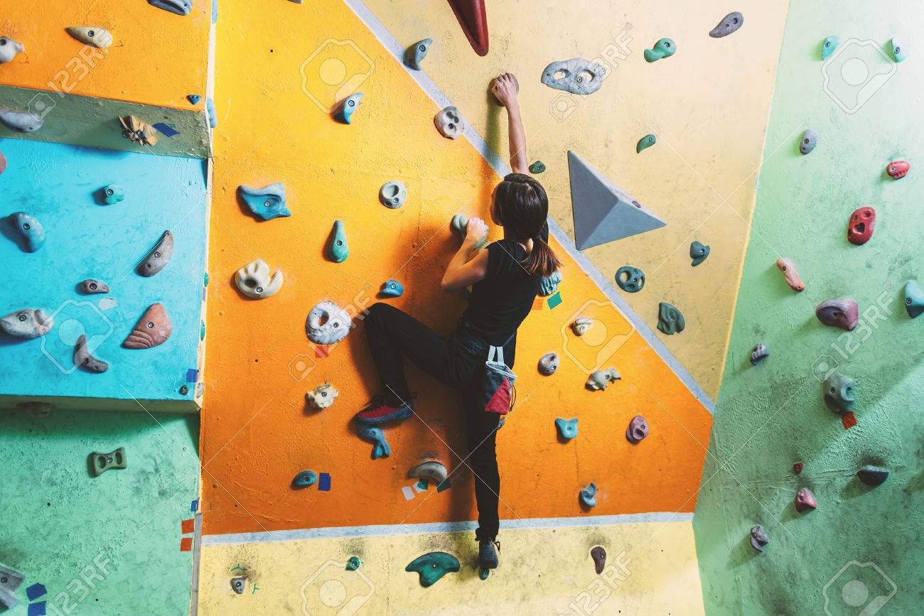 Girl climbing up on practice wall in gym, rear view - 35640653 Girl climbing up on practice wall in gym, rear view - 35640653