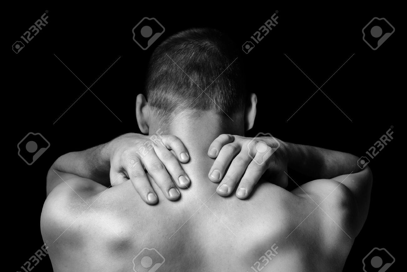Unrecognizable man touches neck, pain in the neck, rear view - 37665684 Unrecognizable man touches neck, pain in the neck, rear view - 37665684