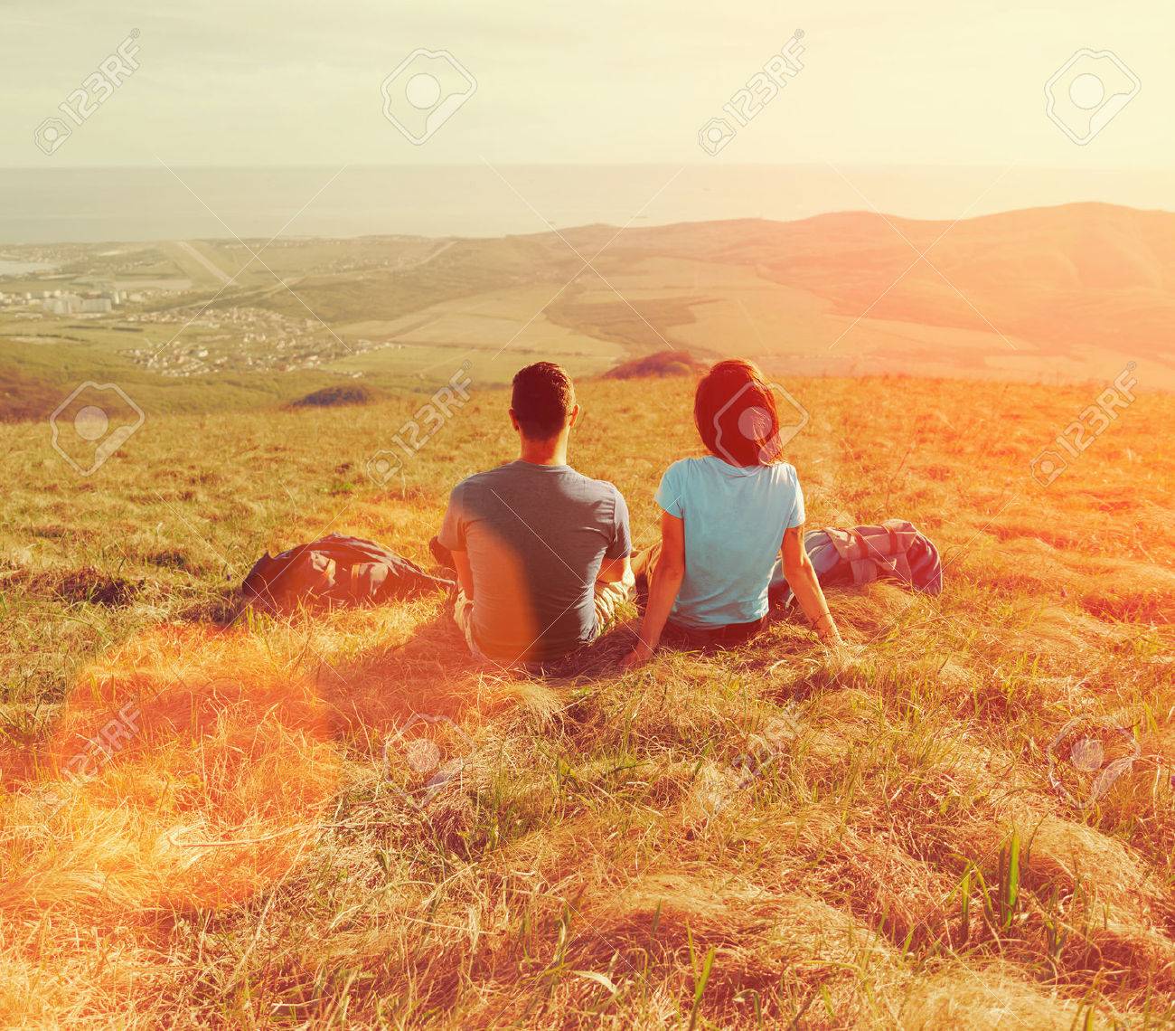 Loving couple sitting on mountain meadow and enjoying view of nature at sunny day in summer - 41121673 Loving couple sitting on mountain meadow and enjoying view of nature at sunny day in summer - 41121673