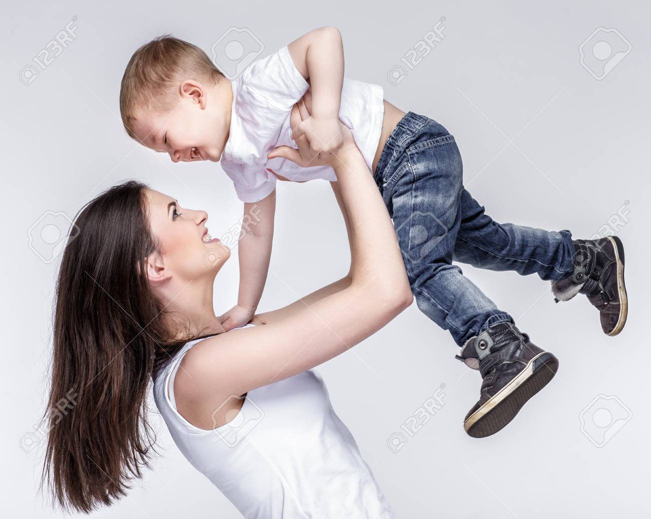 happy young mother with a child on light grey background - 52123572 happy young mother with a child on light grey background - 52123572