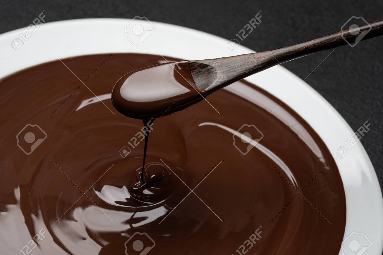 Macro of Melted milk or dark chocolate swirl in plate and spoon on concrete background - 120732543 Macro of Melted milk or dark chocolate swirl in plate and spoon on concrete background - 120732543