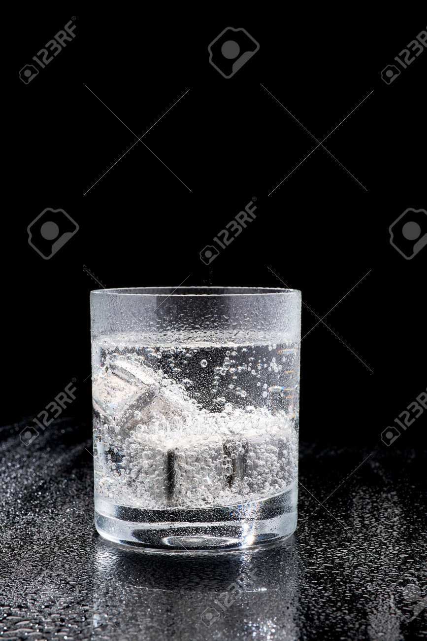 Glass of Soda or Coctail with steel cooling cubes on dark glass background - 169835484 Glass of Soda or Coctail with steel cooling cubes on dark glass background - 169835484
