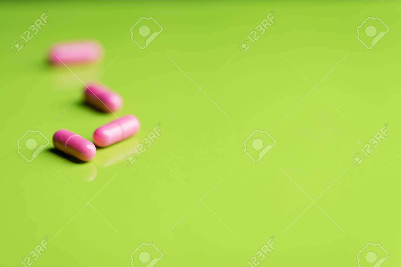 ピンクの錠剤と緑のテーブルと Backrgound の薬 の写真素材 画像素材 Image