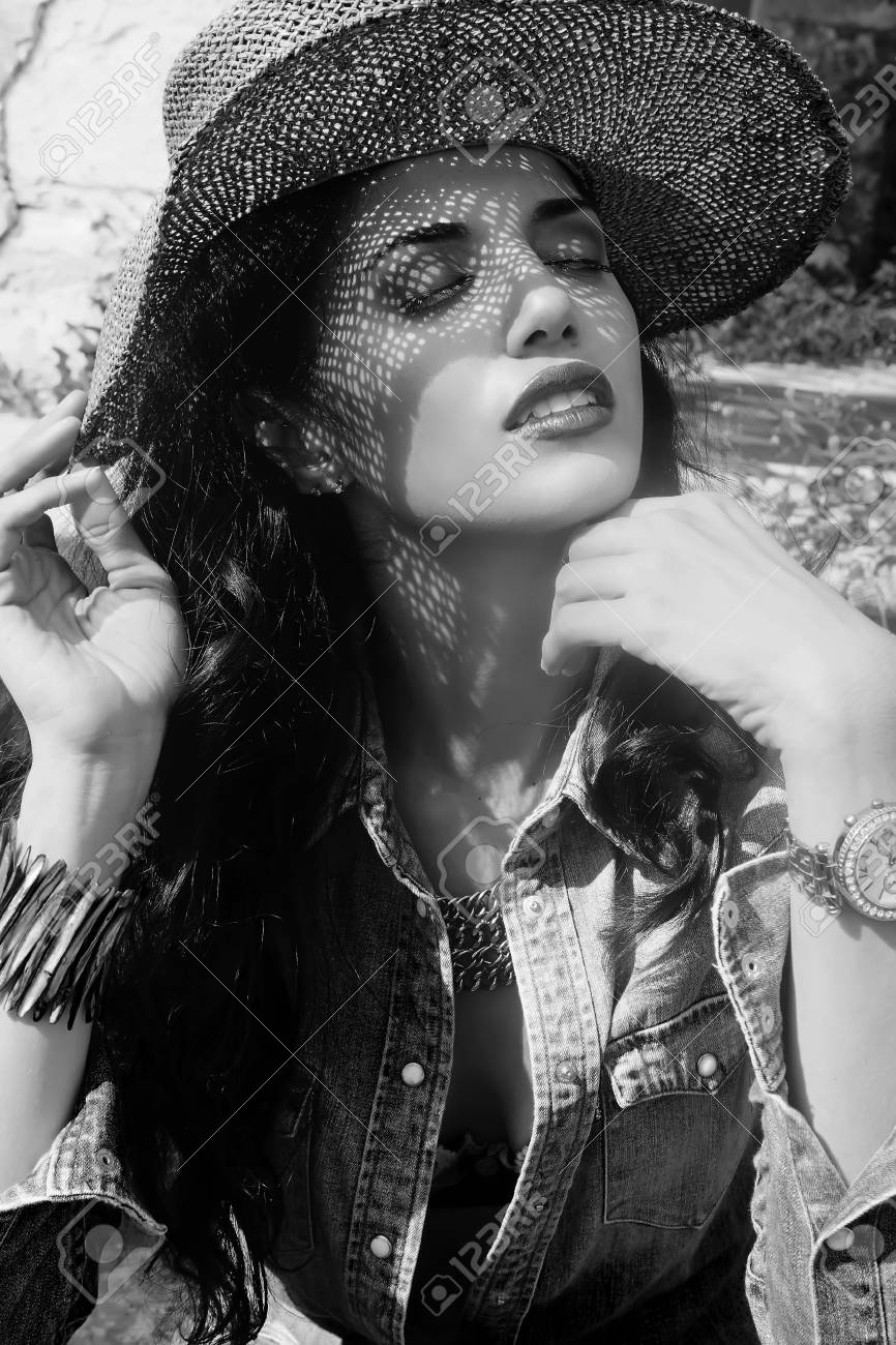 魅力的な若い女性 メイクアップ ダブダブ繊維帽子と彼女の頭をカバーを閉じると 彼女の目を持つ彼女の顔に影をキャストのイメージはブラウスとデニムのショート パンツを着て ブラウスの胸の谷間が ウォマのブラジャーを参照してくださいすることができます の写真