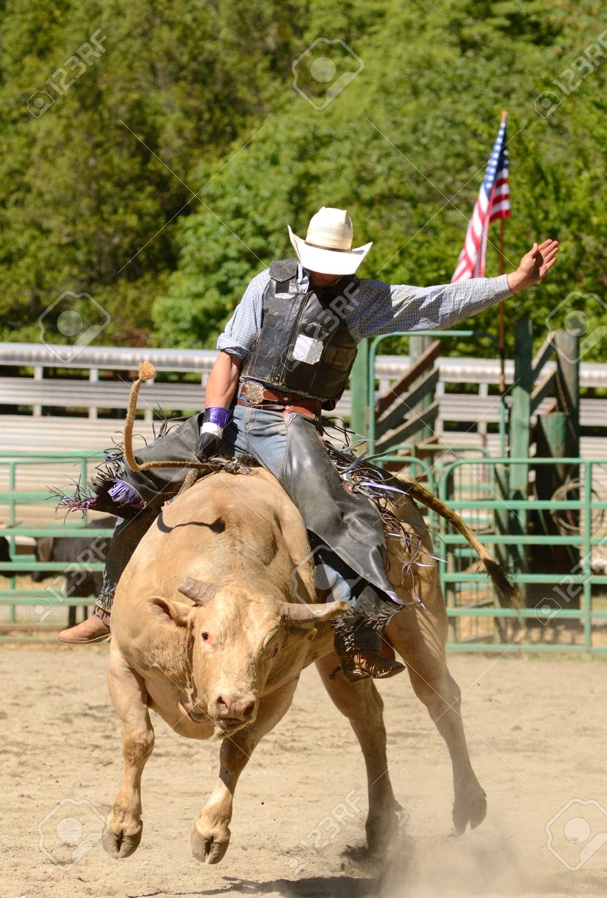 カウボーイパンチョ雄牛でオレゴン州の小さな夏のロデオの競争に乗って牛の中に の写真素材 画像素材 Image カウボーイパンチョ雄牛でオレゴン州の小さな夏のロデオの競争に乗って牛の中に の写真素材 画像素材 Image