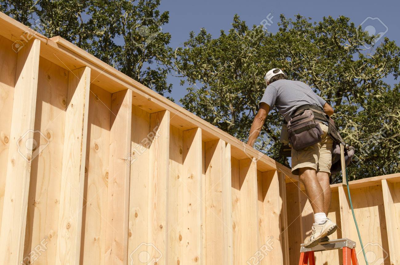 Wood Frame Wall framing construction contractor installing a top plate on a corner Wood Frame Wall framing construction contractor installing a top plate on a corner