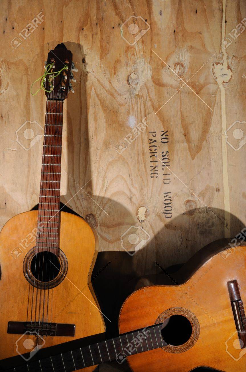 Two Old Acoustic Guitars Against Grunge Aged Surface Stock Photo Two Old Acoustic Guitars Against Grunge Aged Surface Stock Photo