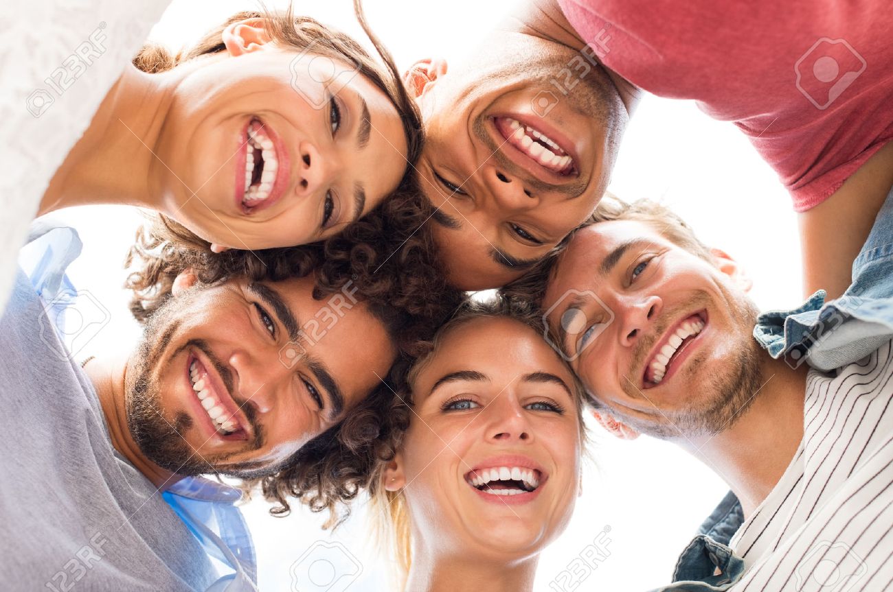 Directly below shot of young friends forming huddle. Low angle view of girls and guys with their head forming a circle. Portrait of young people looking at camera. Friendship and unity concept. - 59968115 Directly below shot of young friends forming huddle. Low angle view of girls and guys with their head forming a circle. Portrait of young people looking at camera. Friendship and unity concept. - 59968115