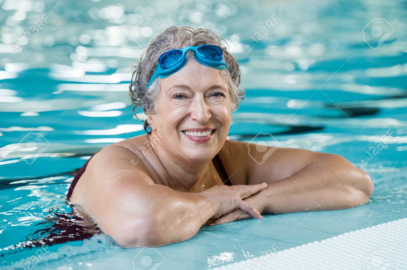 海水浴　おばさん水着 熟女の水着を着てプールでゴーグルします。プールに立って、カメラを見て退職を楽しんでいるアクティブなシニア女性に合います。ハッピー  シニア健康老婆アクティブなライフ スタイルを楽しんでいます。の写真素材・画像素材 Image 65157695