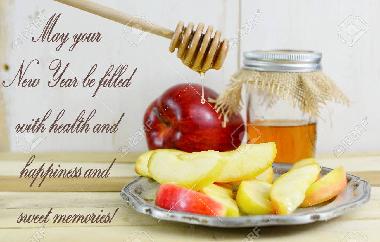 Rosh hashanah image of honey and apple with sliced apple on a pewter plate. the honey is in a canning jar with burlap top and is being drizzled on the sliced apples from a honey dipper. happy new year greeting - 73576538