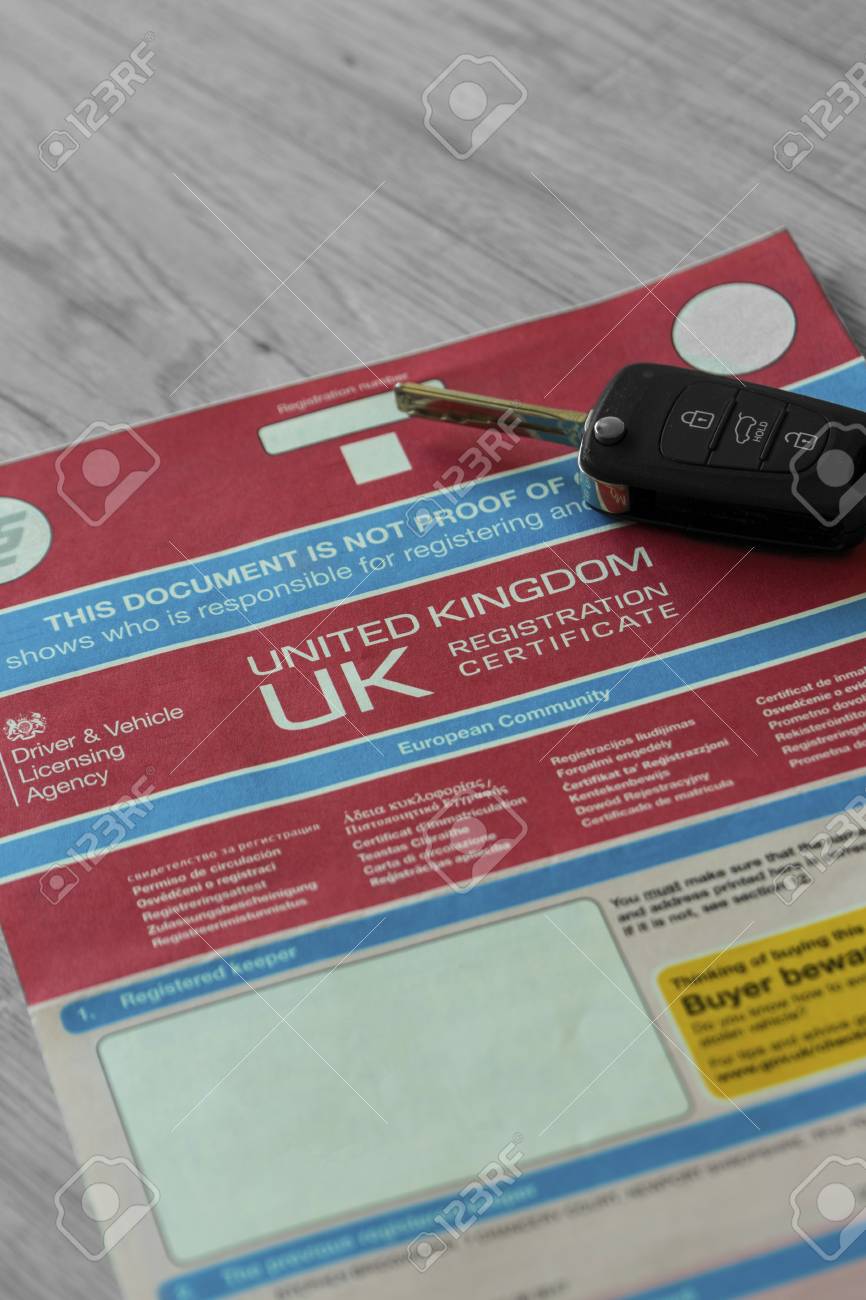v5c car log book with electronic key fob on a grey wood background what is a car log book
