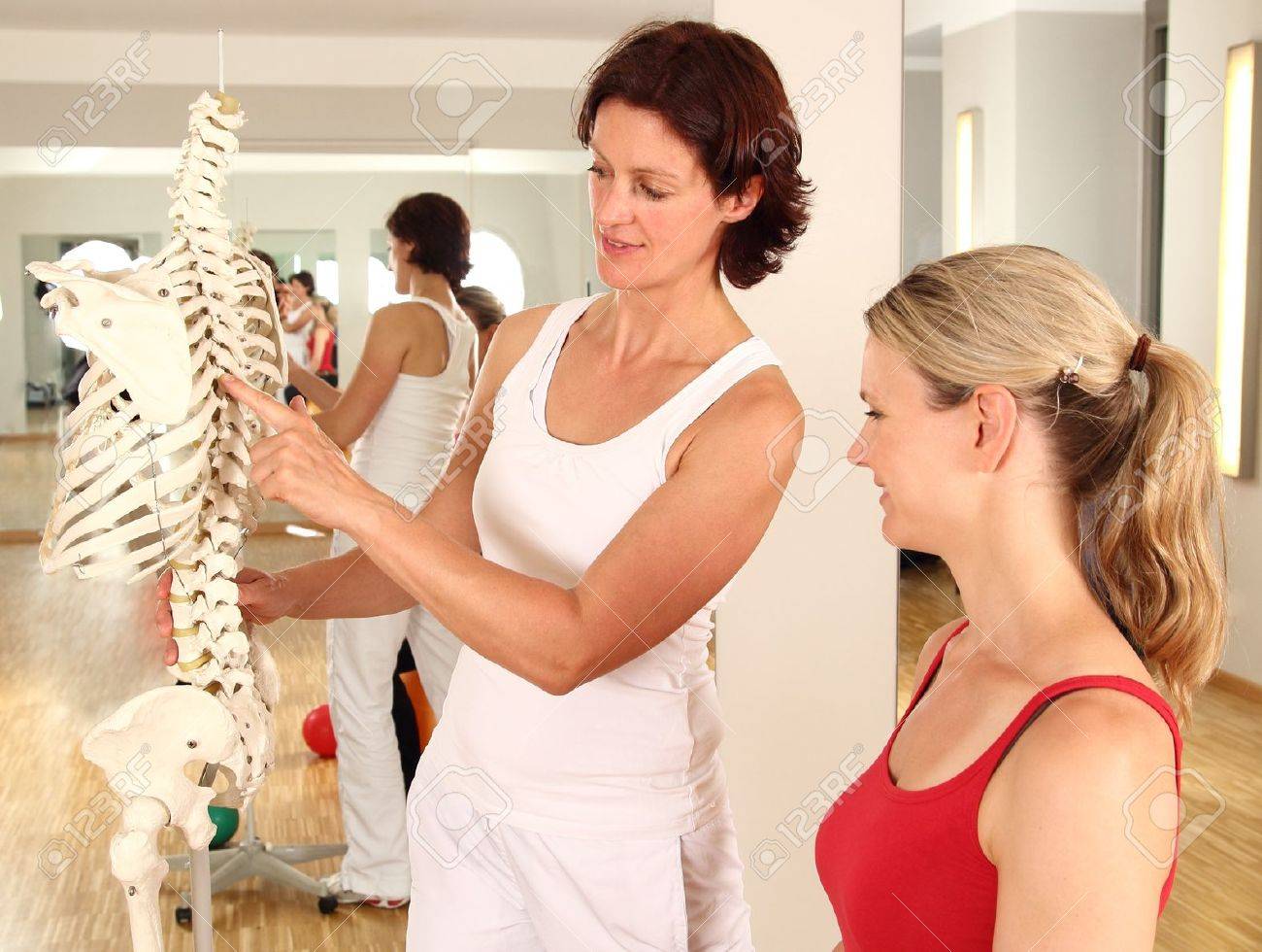 Physiotherapist explaining the spine - 21138820 Physiotherapist explaining the spine - 21138820