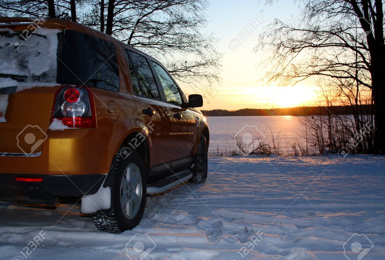Car by frozen lake at sunset - 11581696 Car by frozen lake at sunset - 11581696