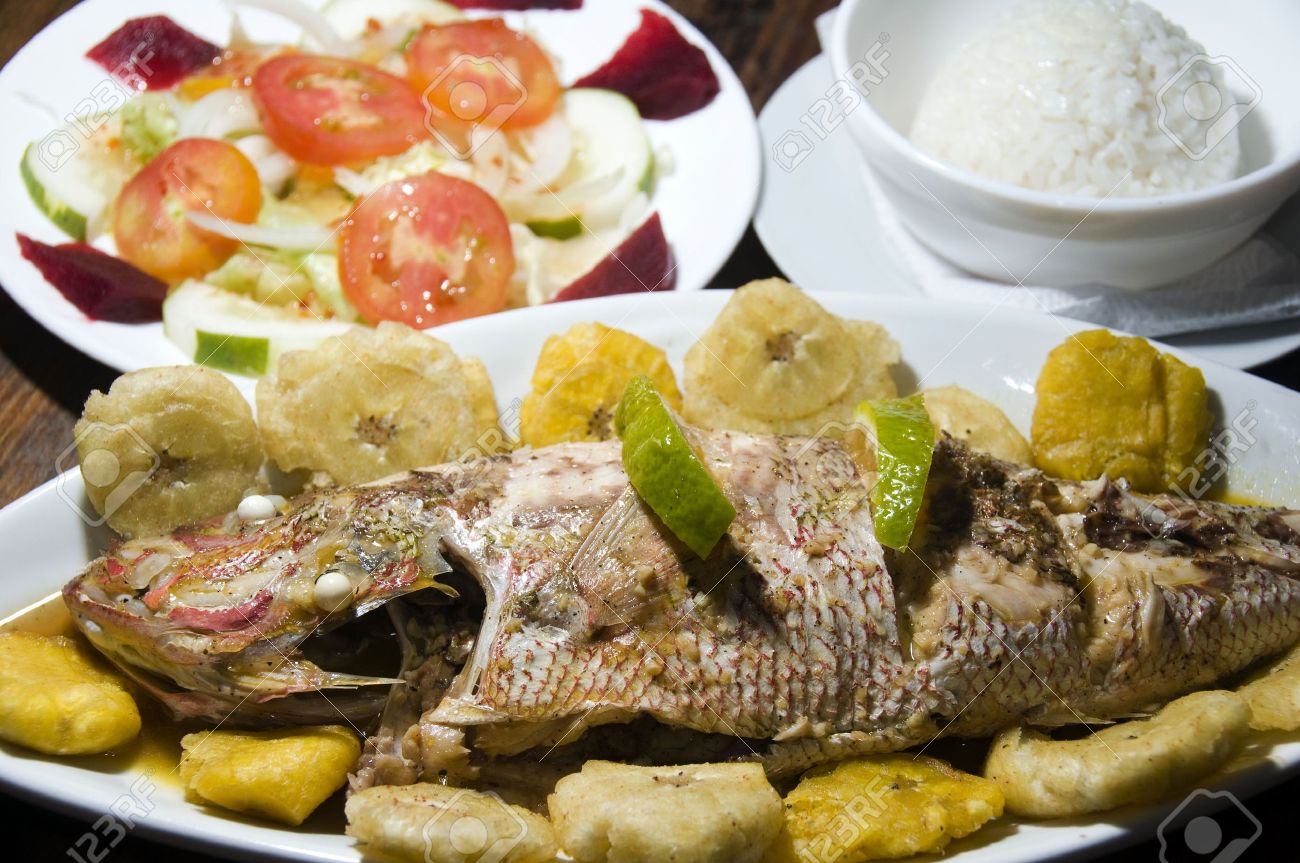 中央アメリカの典型的な王の完全な夕食魚と全体の魚夕食揚げバナナ Tostones 米黄色の尾と地元の新鮮な料理サラダ コーン島ニカラグア中央アメリカで撮影しました の写真素材 画像素材 Image