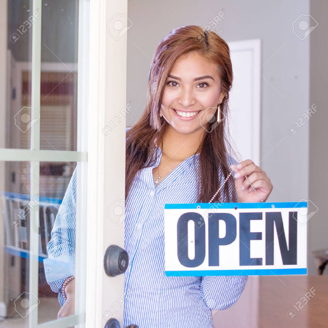 Woman opening her store with an open sign - 45354708 Woman opening her store with an open sign - 45354708