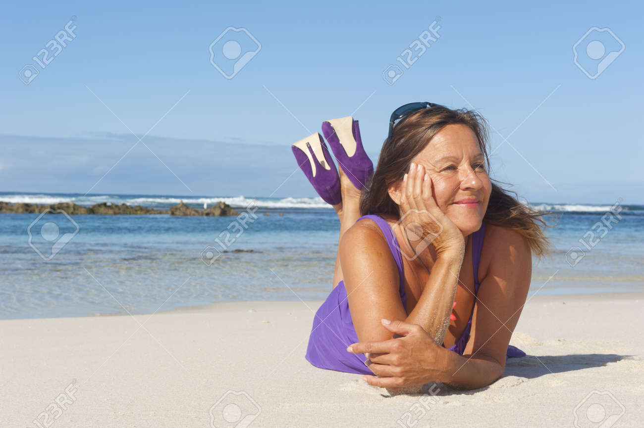 Jolie Femme Mature A La Recherche En Robe Pourpre Sexy Et Chaussures A Talons Hauts A La Plage Avec Vue Mer Et Ciel Bleu En Arriere Plan Et L Espace De Copie Banque D Images