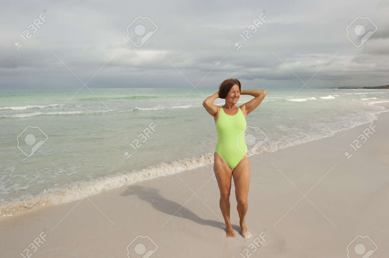 美しい中年の女性水浴熱帯浜海と曇り空の背景とコピー スペースとして分離 健康でアクティブな退職を楽しんで幸せで の写真素材 画像素材 Image