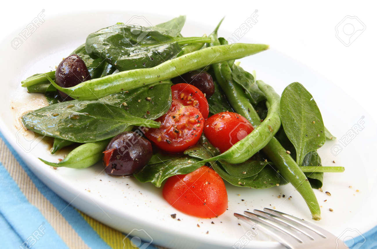 sald of spinach leaves chery tomatoes green beans and black