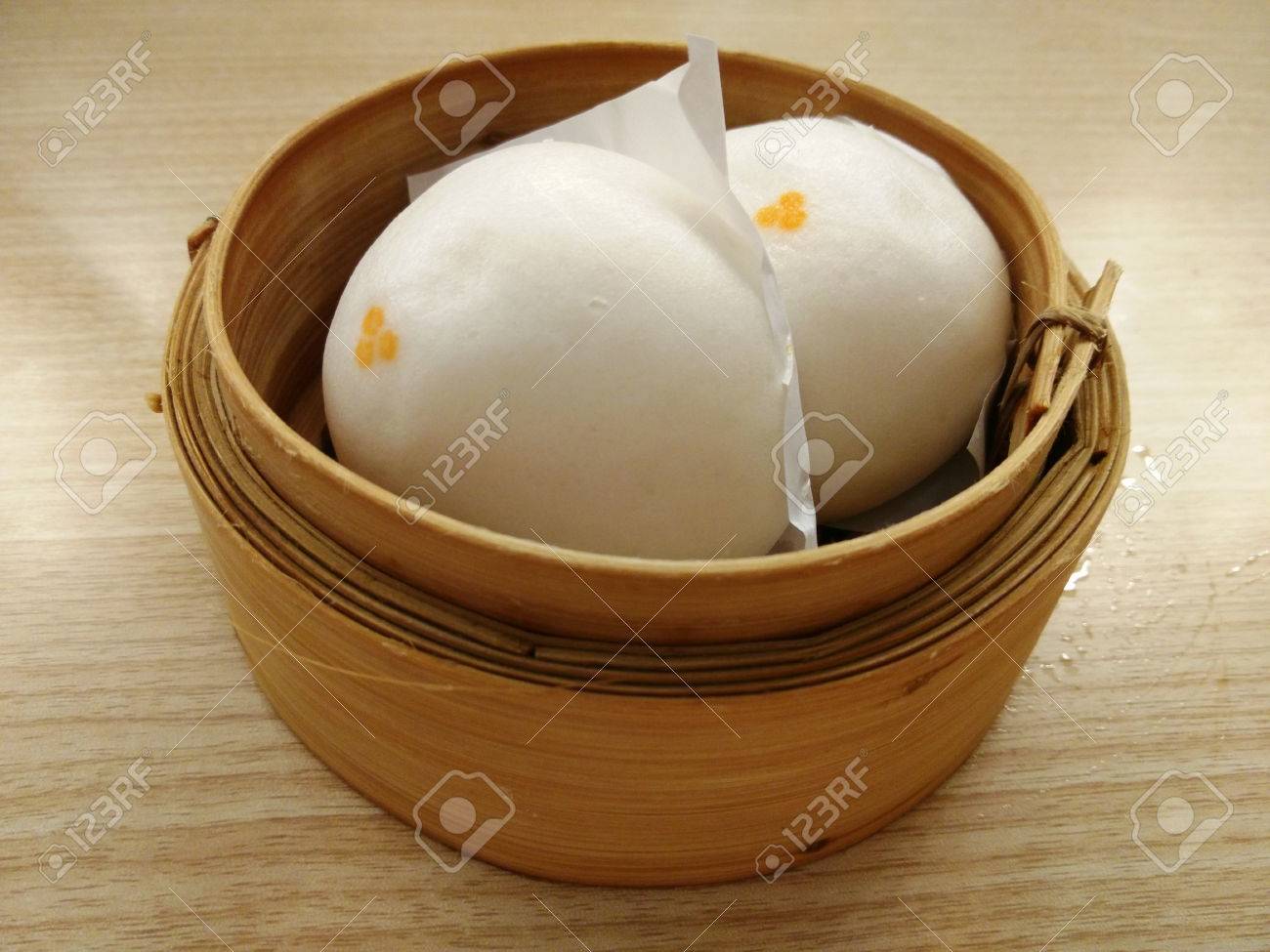 two siopao or chinese steamed bun in a bamboo steamer stock photo