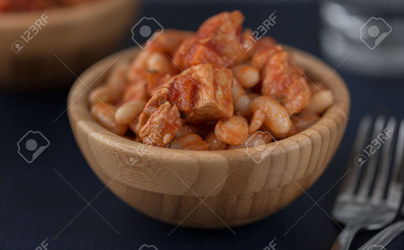 Pork stew with white beans in a wooden bowl. - 166239637 Pork stew with white beans in a wooden bowl. - 166239637