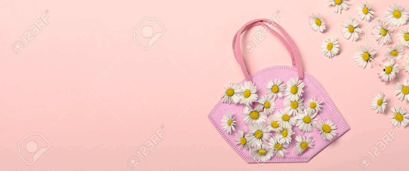 Creative flat lay with daisy flowers and pink fpp2 or KN95 mask - 167779885 Creative flat lay with daisy flowers and pink fpp2 or KN95 mask - 167779885