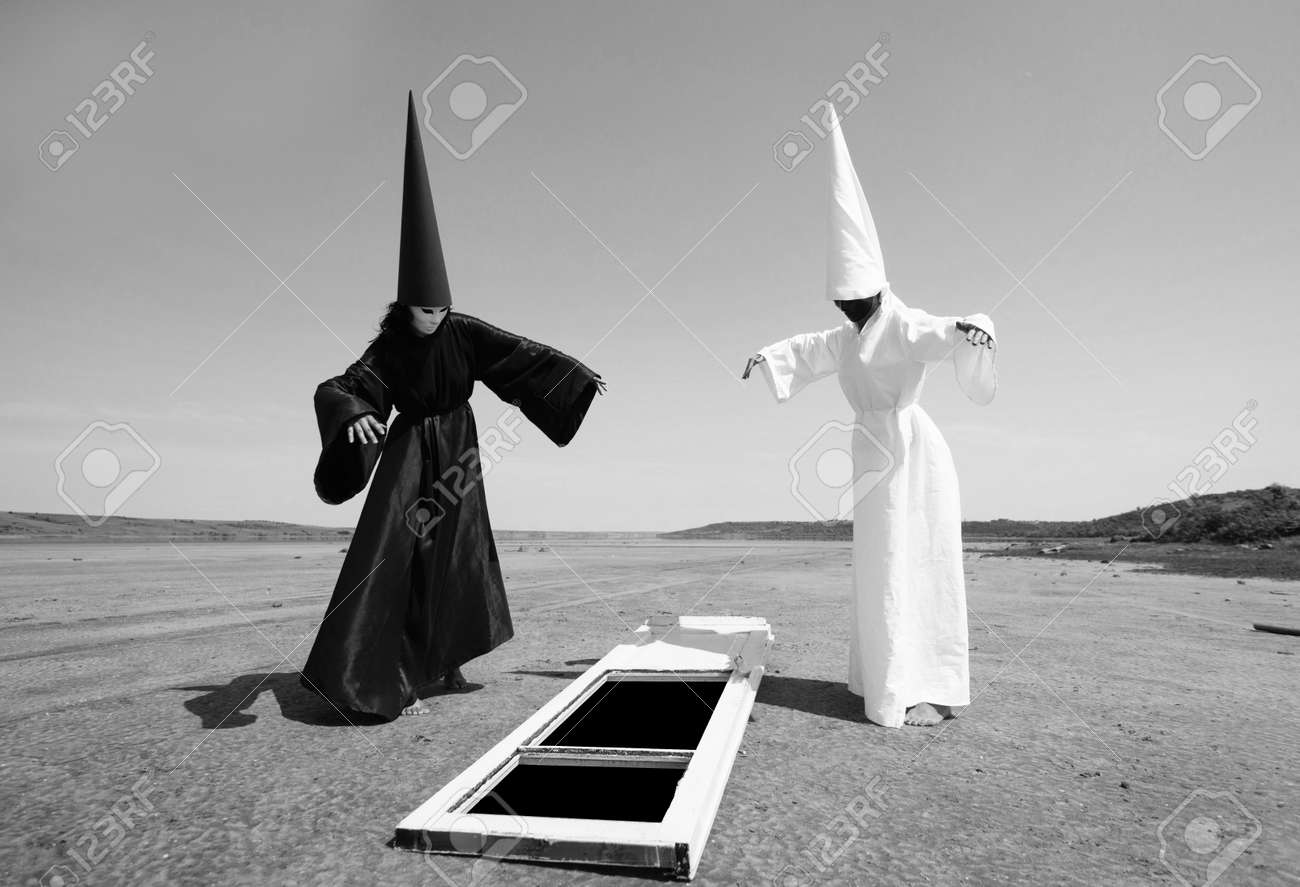 黒マントと白いマントおよび他のアートワークの世界への扉で奇妙な人々 の写真素材 画像素材 Image