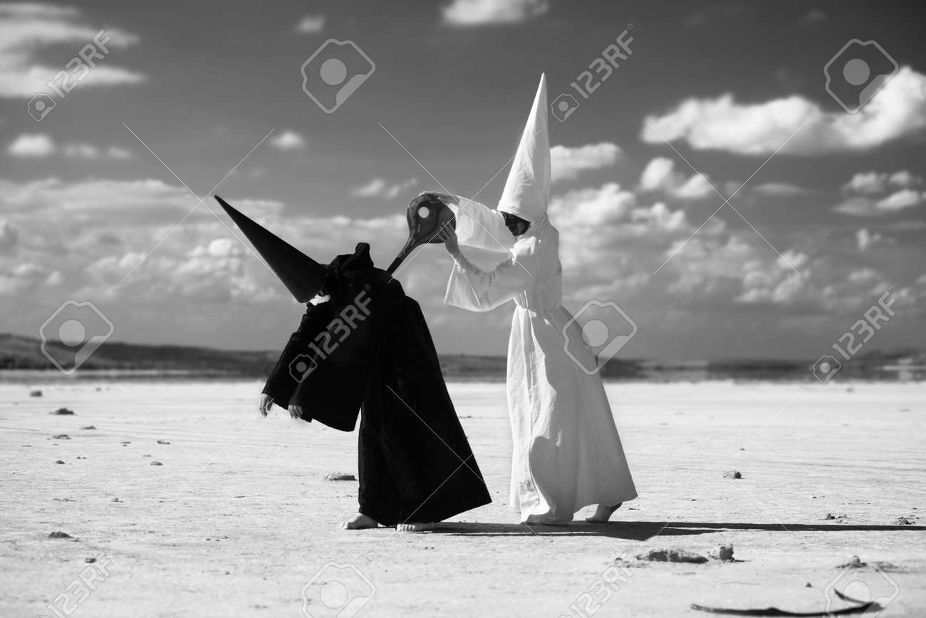 砂漠のアートワークにブラック マントで別の図を巻き 白いマントで奇妙な図 の写真素材 画像素材 Image