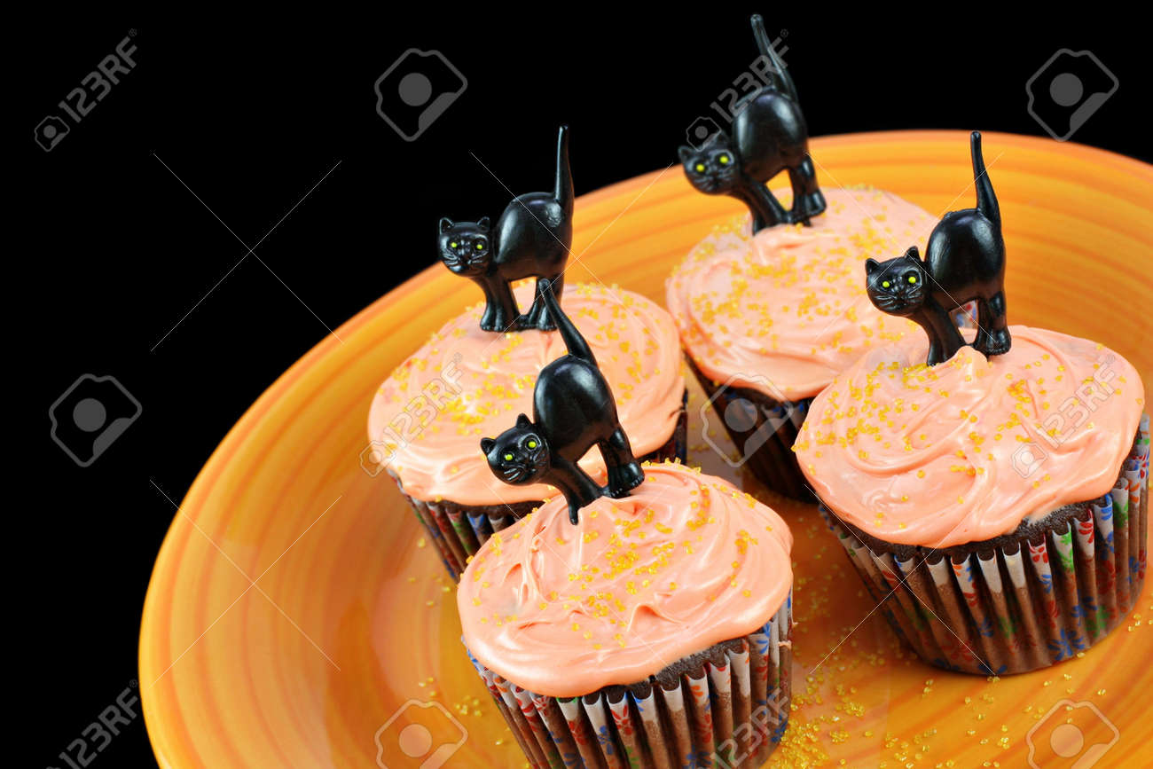 halloween cupcakes chocolate cupcakes with peach frosting on an orange plate decorated for halloween with - Halloween Decorated Cupcakes halloween cupcakes chocolate cupcakes with peach frosting on an orange plate decorated for halloween with - Halloween Decorated Cupcakes