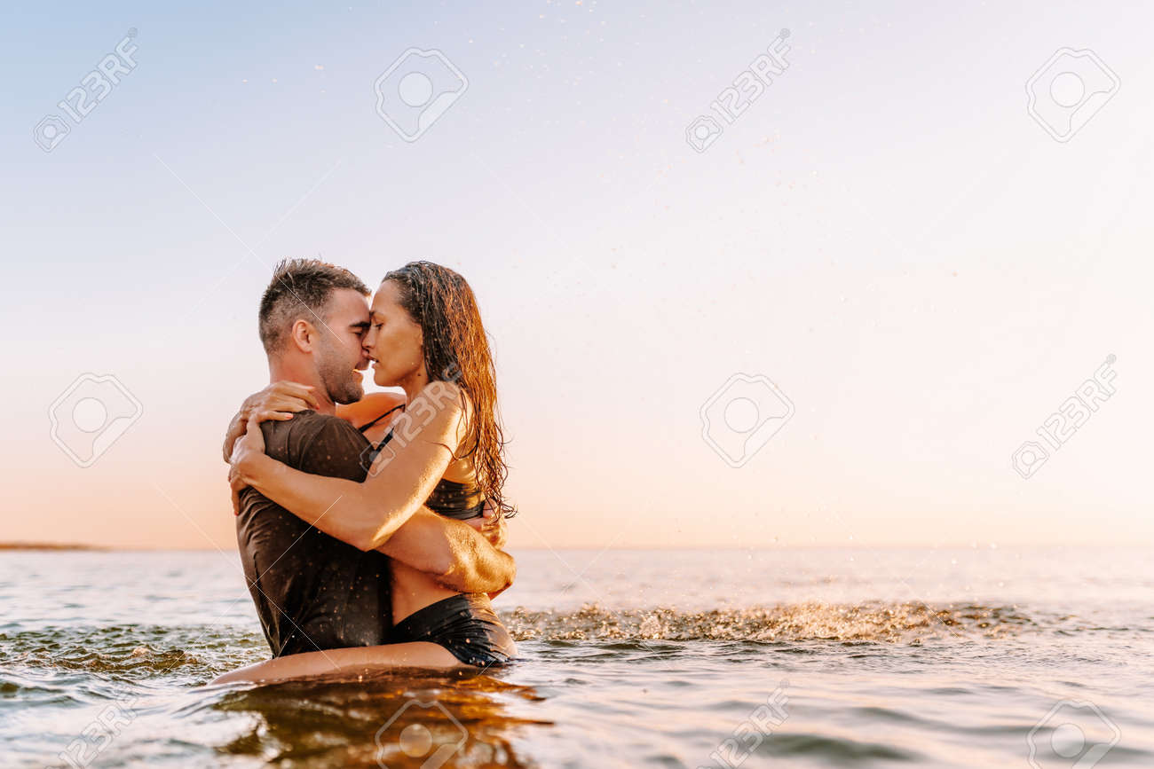 Happy Young Fit Couple In Sea Or Ocean Hug Each Other With Love At Summer  Sunset. Romantic Mood, Tenderness, Relationship, Vacation Concept. Stock  Photo, Picture and Royalty Free Image. Image 167169364., image size:1300x867