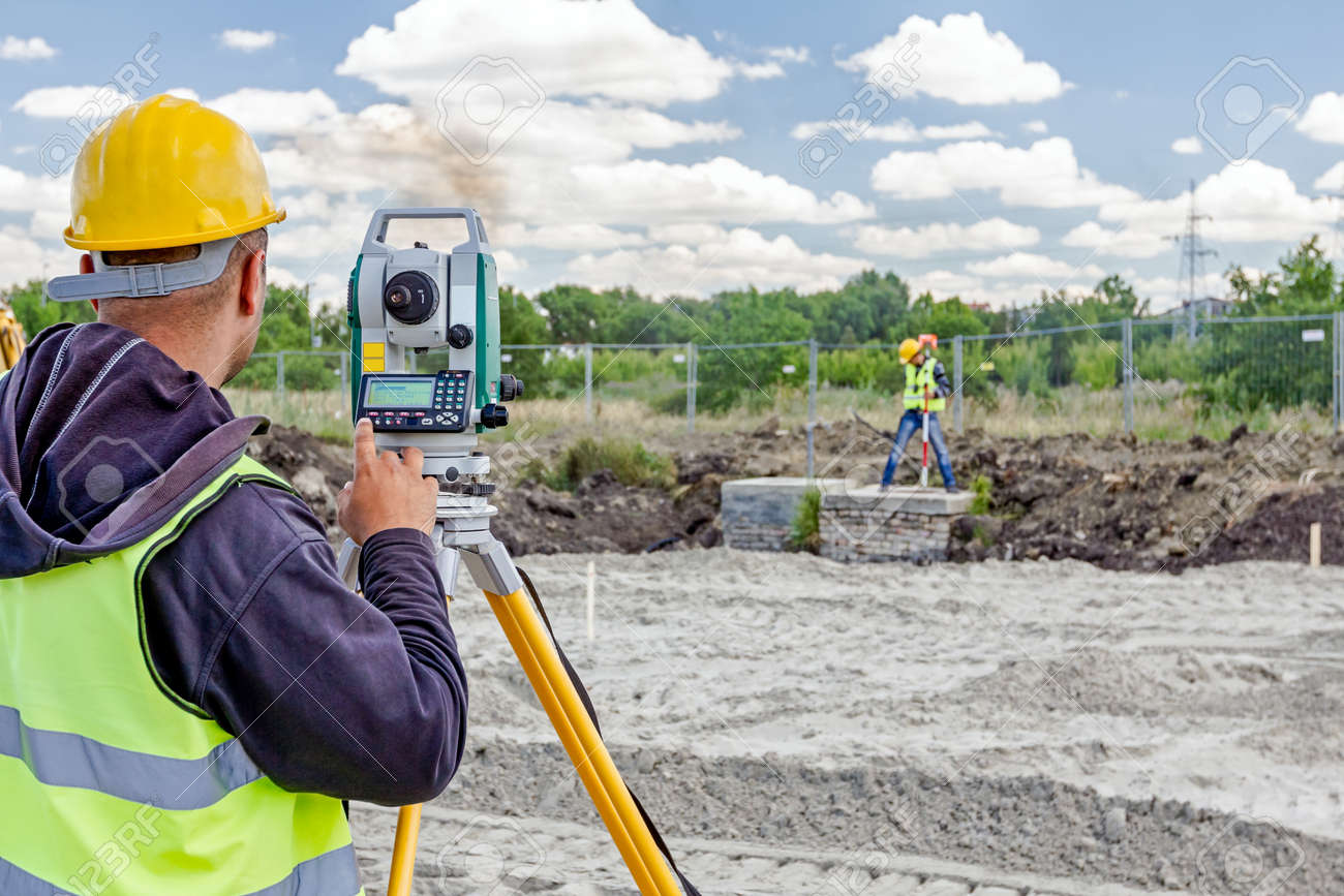 Surveyor engineer is measuring level on construction site. Surveyors ensure precise measurements before undertaking large construction projects. - 63172531 Surveyor engineer is measuring level on construction site. Surveyors ensure precise measurements before undertaking large construction projects. - 63172531