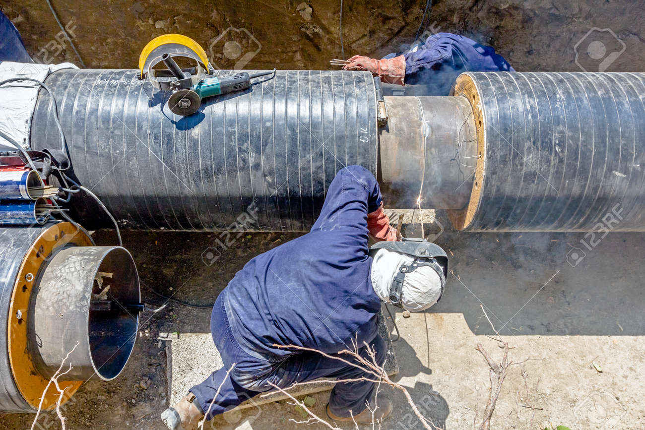 team of welders is in trench working hard to install a new pipeline welding pipe line