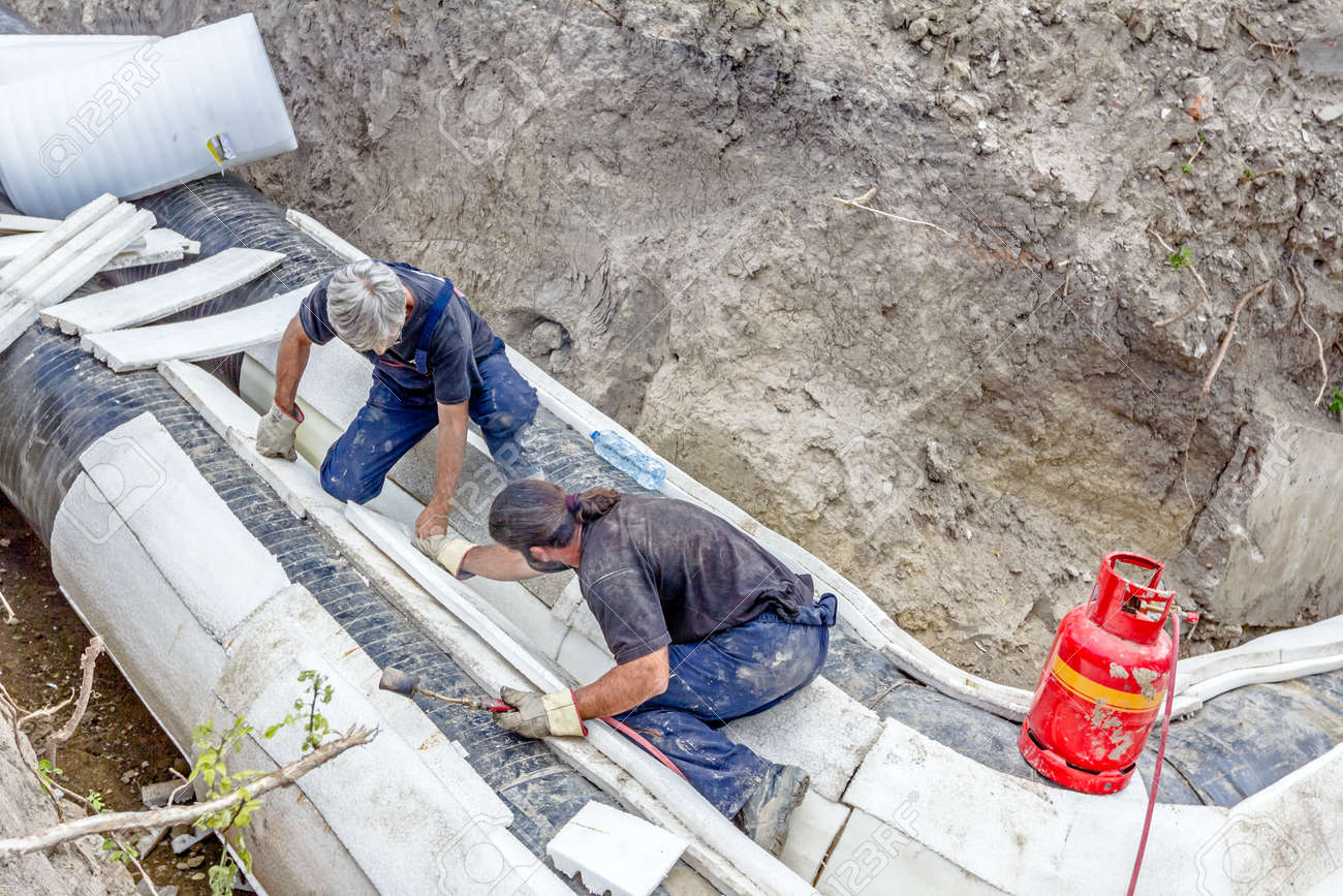 team of riggers is affix thermal protection on isolated pipeline