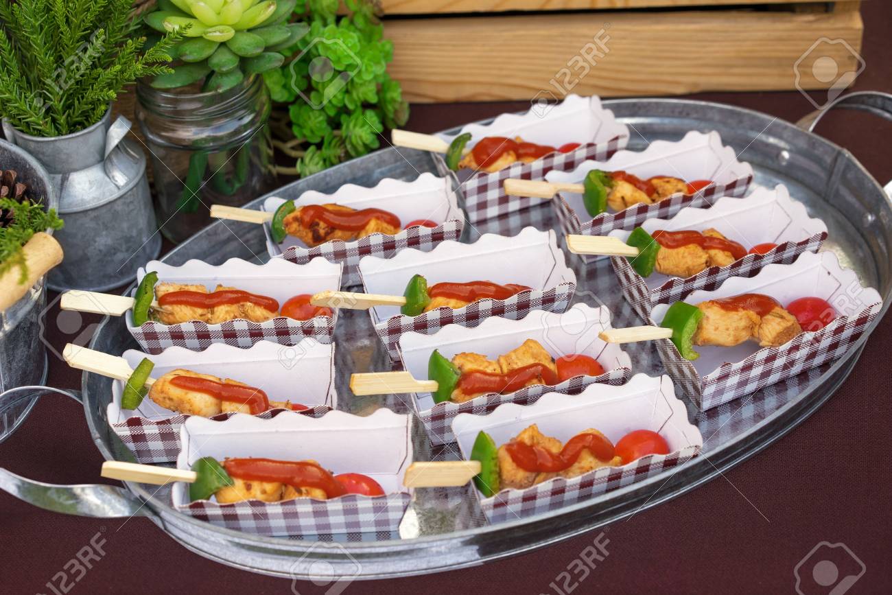 Banque d\u0027images , Garden party traiteur, décoration et une table servie avec de la nourriture et des plaques. Chicken Barbecue canape close up