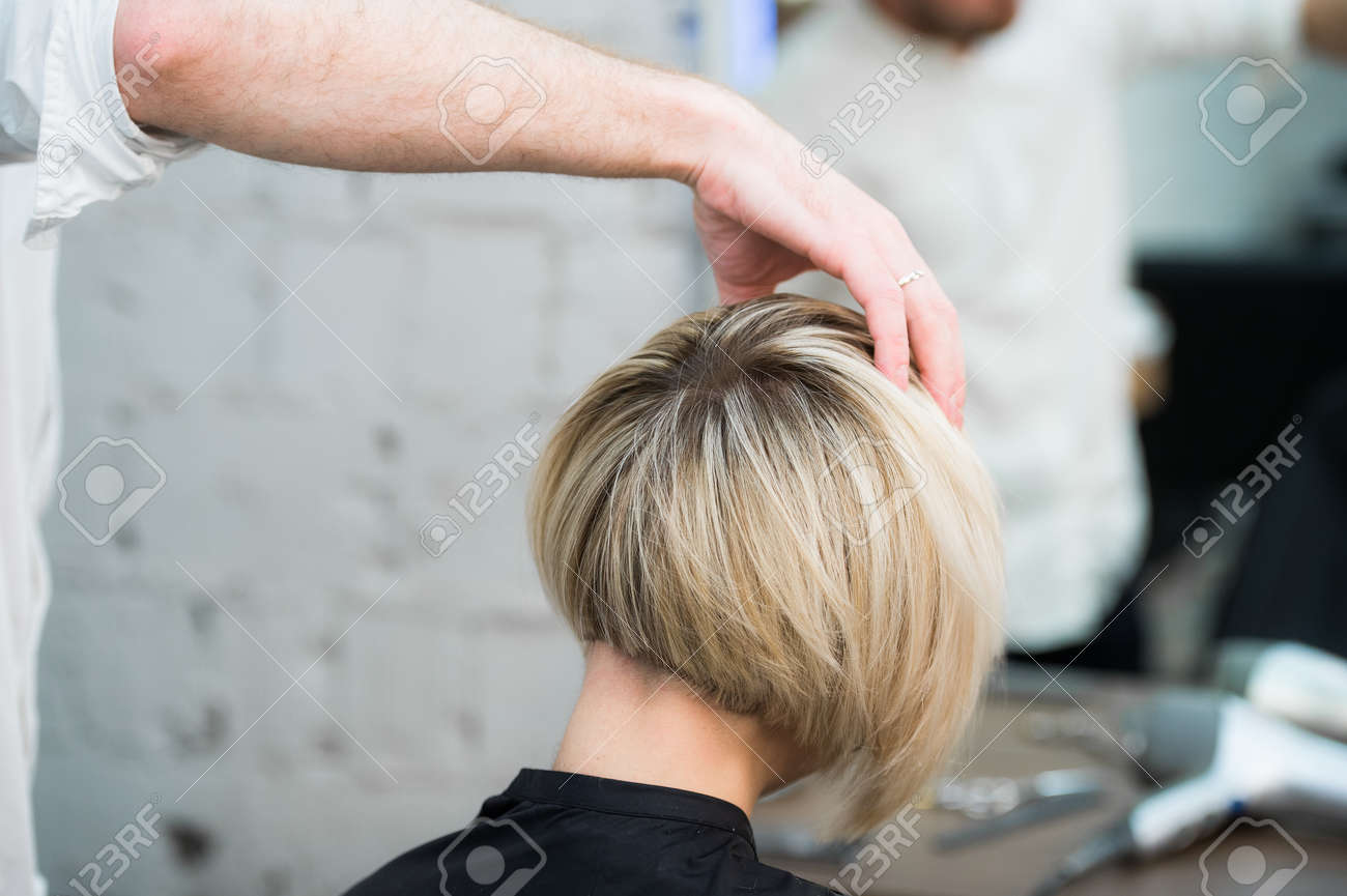 Closeup portrait teen young girl woman sitting in chair in hair salon looking in mirror while hairdresser checking her new haircut. - 60417886 Closeup portrait teen young girl woman sitting in chair in hair salon looking in mirror while hairdresser checking her new haircut. - 60417886