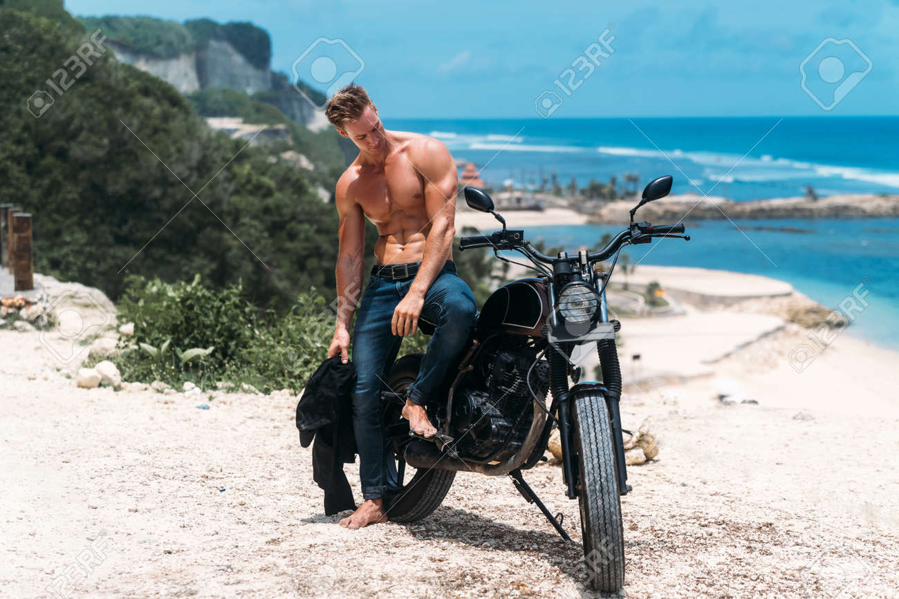 120991456-sexy-athletic-man-with-perfect-naked-body-sitting-on-motorbike-ocean-waves-and-beautiful-mountains.jpg